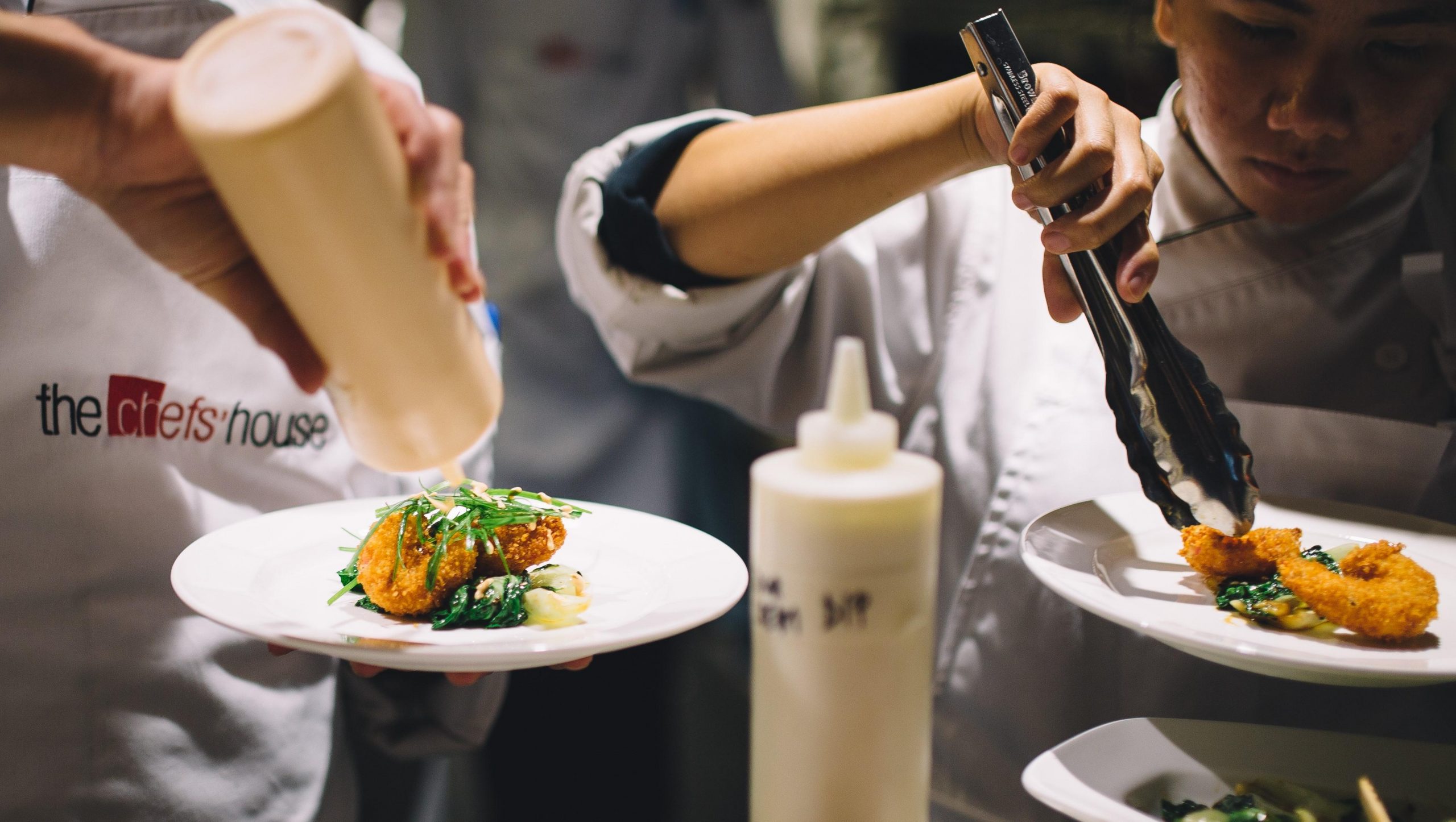 Two cooks prepare food.