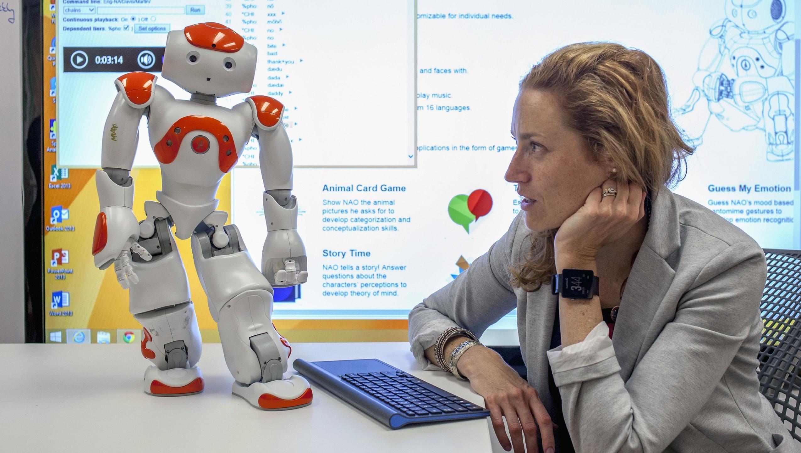 Stephanie Walsh Matthews sits with Max the robot.