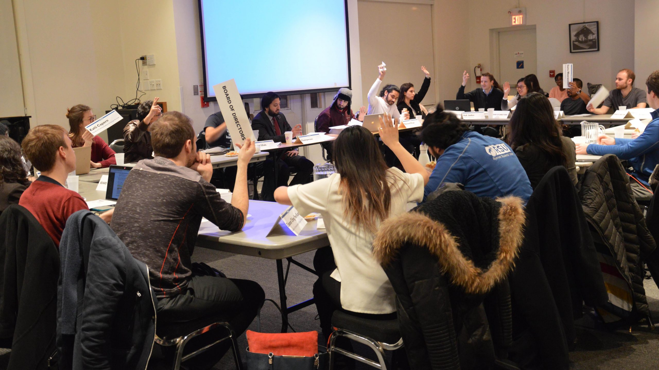 Board members hold up their voting cards