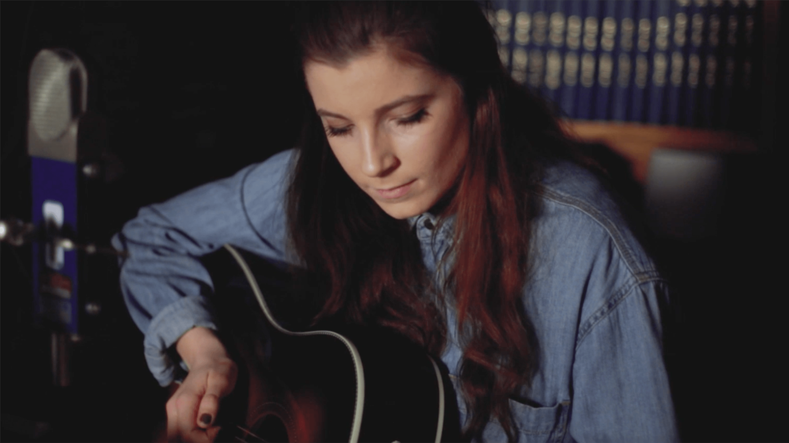 A still image of Adina Vlasov playing the guitar during "Live from the Archives"