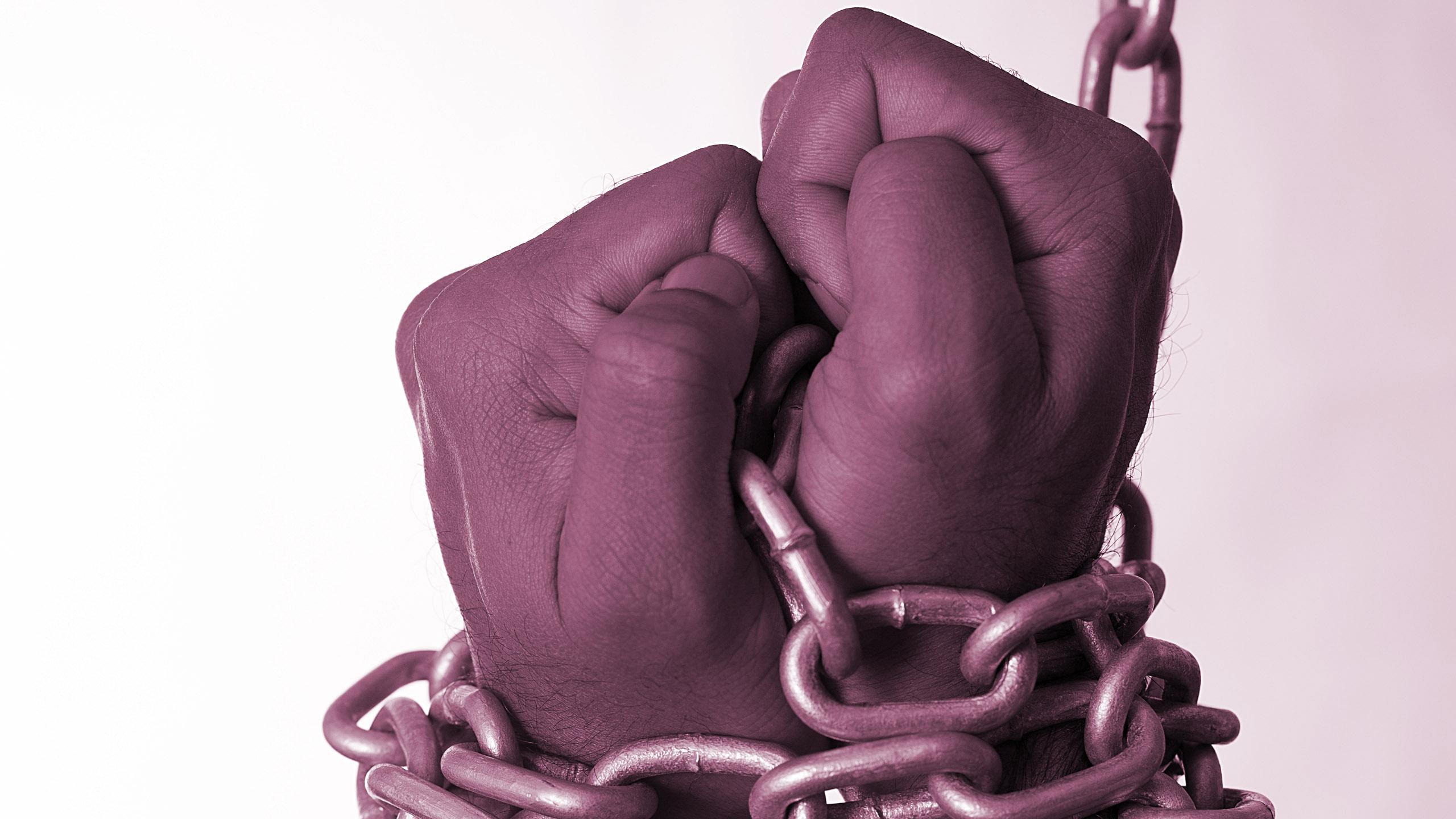 Hands tied up with chains.