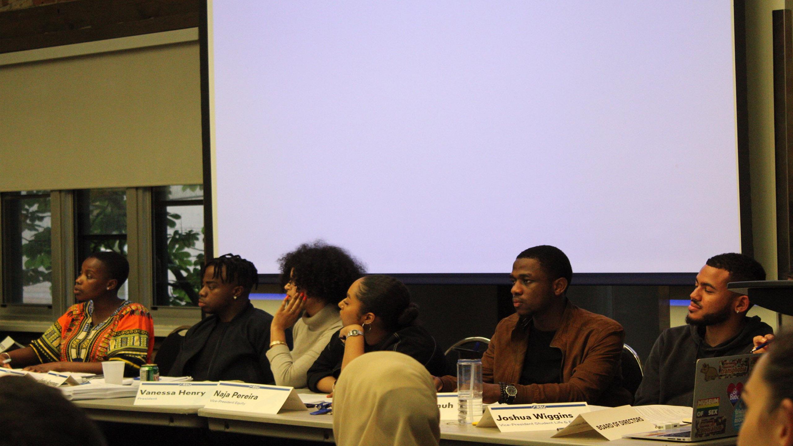 RSU executives sitting at a table during a board meeting