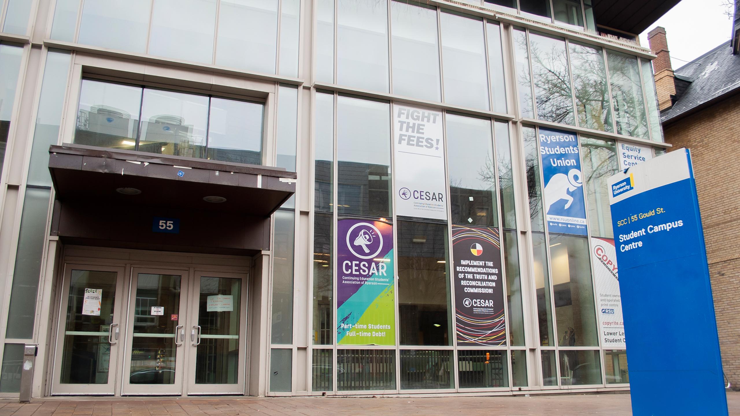 The front of the Student Campus Centre building on Gould Street. A blue sign that reads "Student Campus Centre" stands in front of the building to the right of the picture.