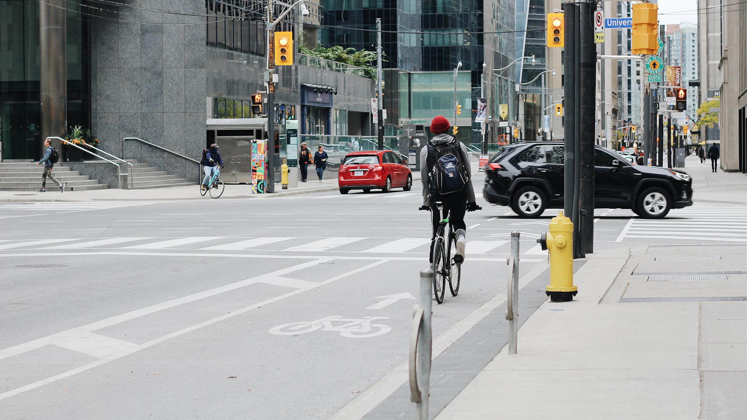 Person riding a bicycle in a bike lane in downtown Toronto.