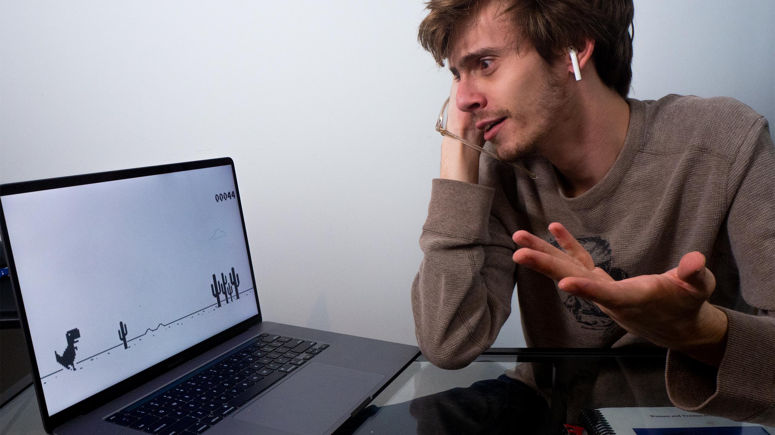 Exasperated student looking at a laptop with no wifi.