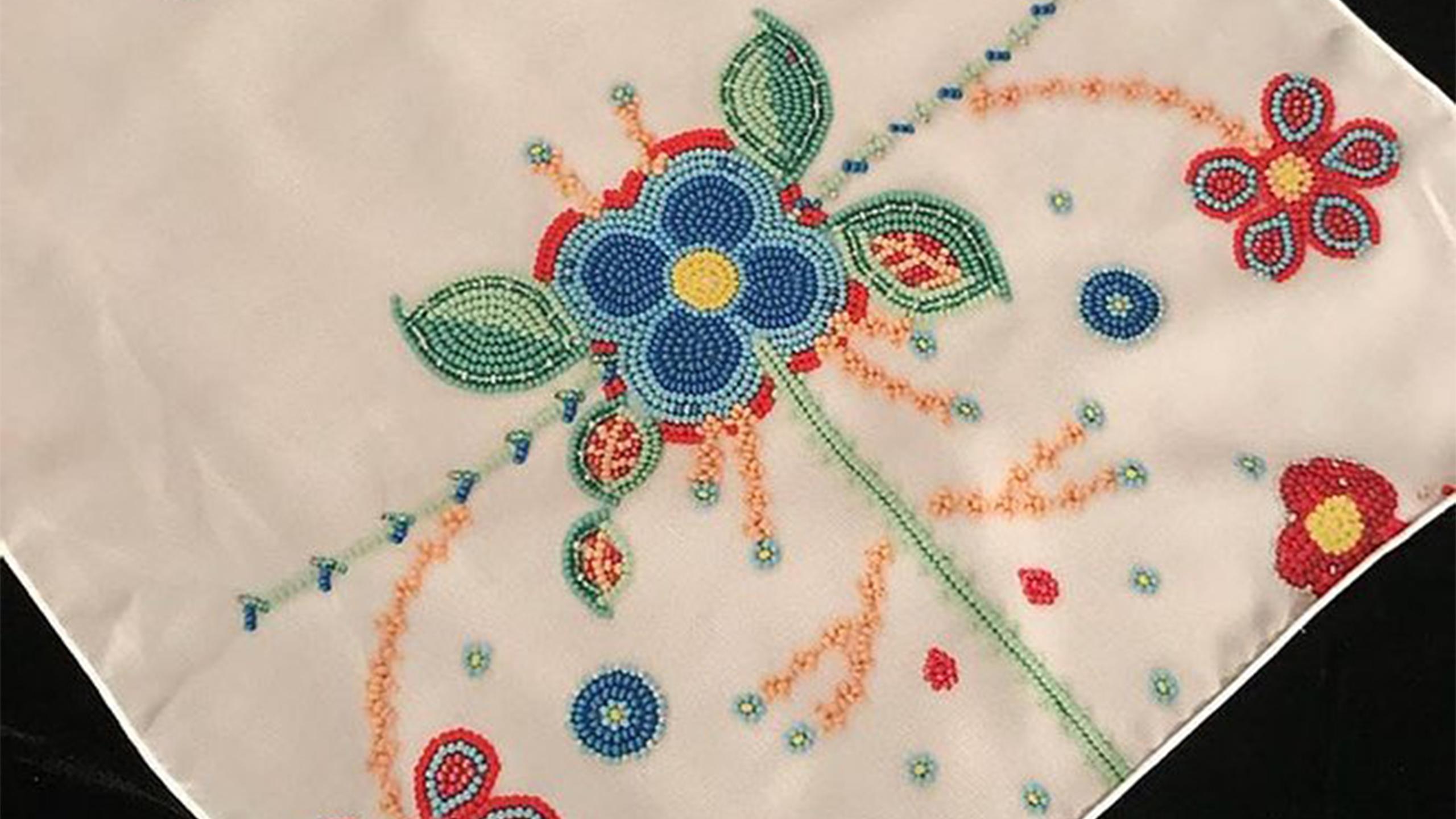 Beaded fabric with an intricate floral pattern.