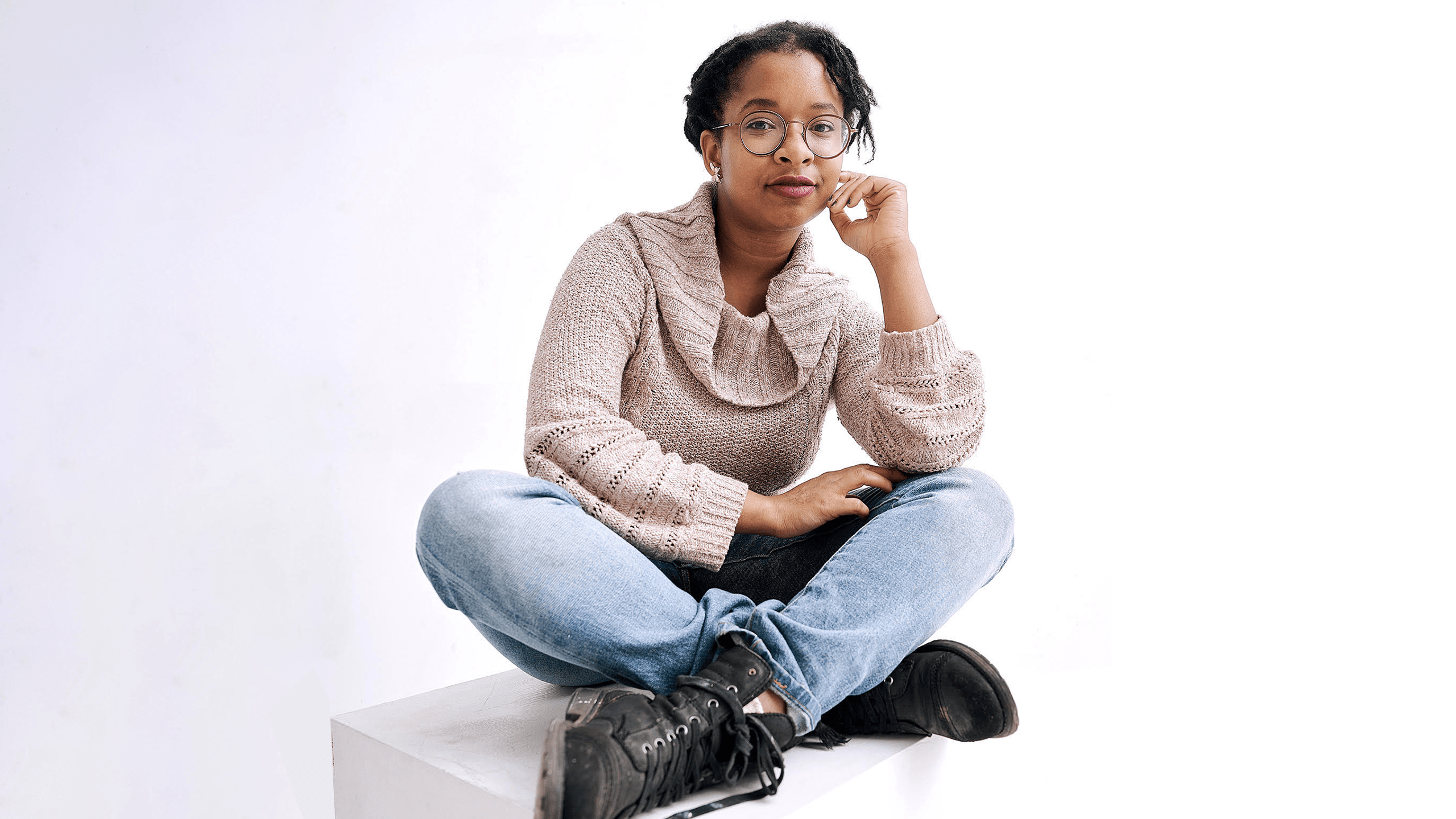 A young person posing cross-legged.