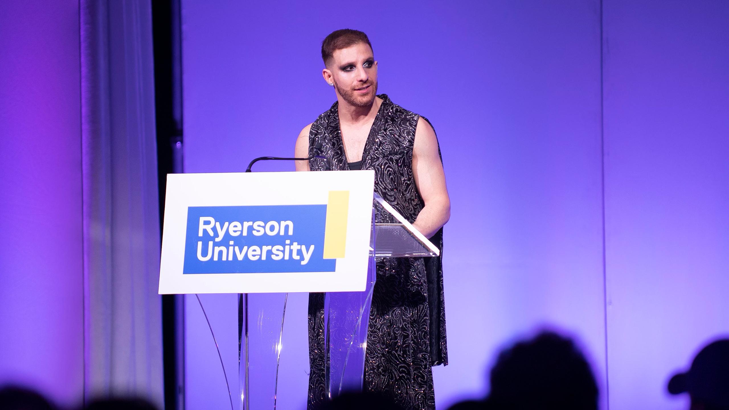 A photo of Ben Barry at a podium that says Ryerson University.