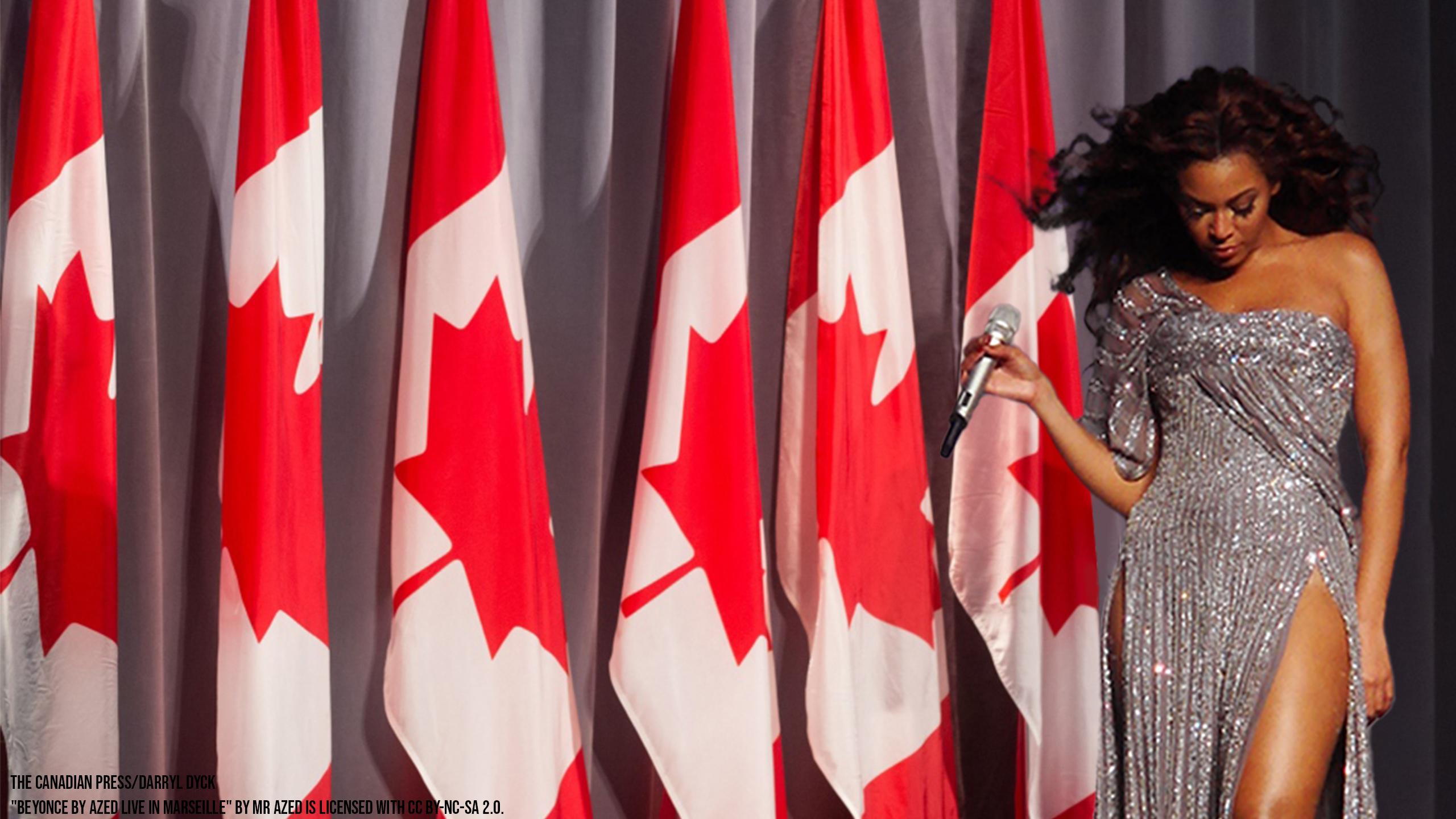 Beyonce standing in front of a row of Canadian flags with a microphone