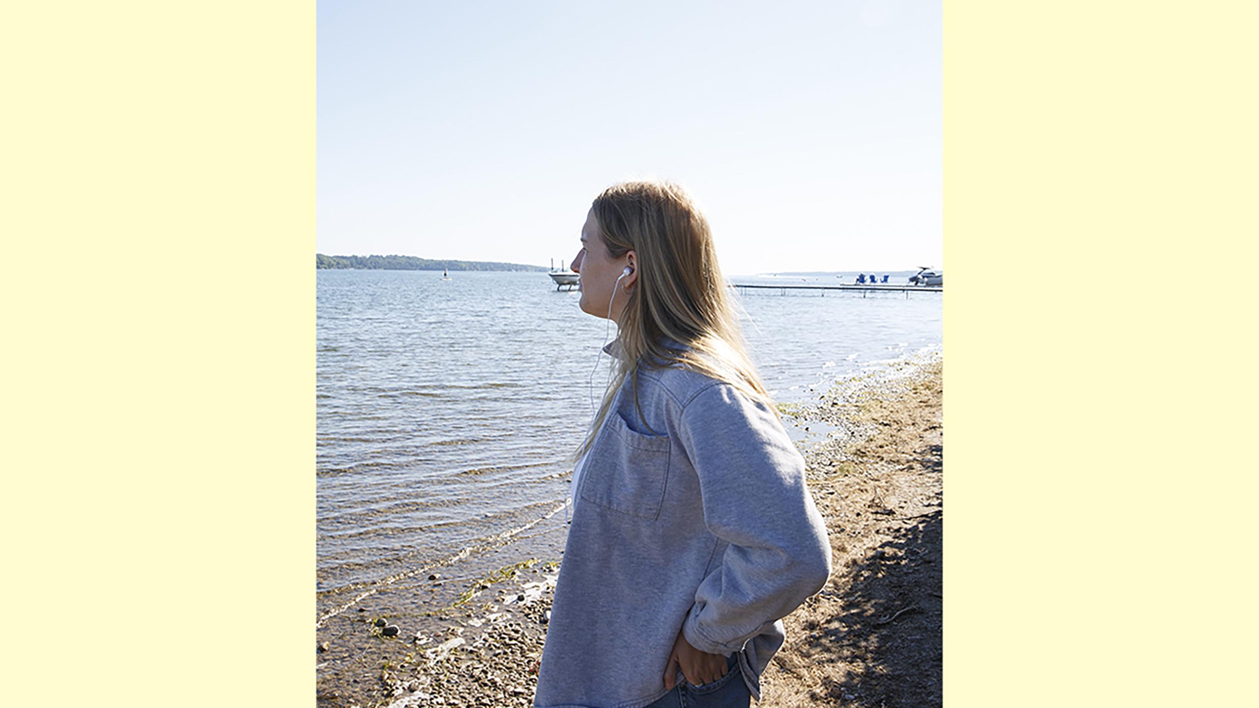 A woman listening to music at the beach