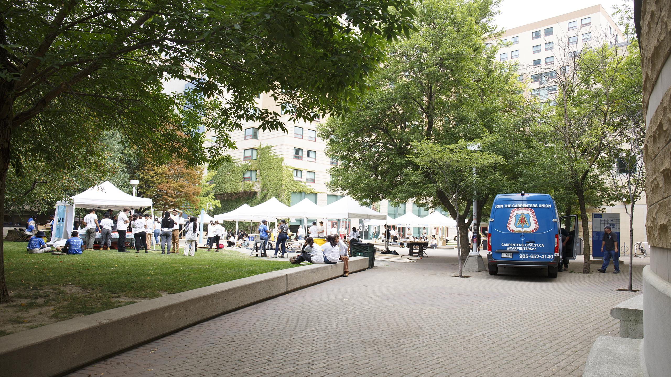 Landscape view of an exciting wood working event occuring in front of Pitman hall
