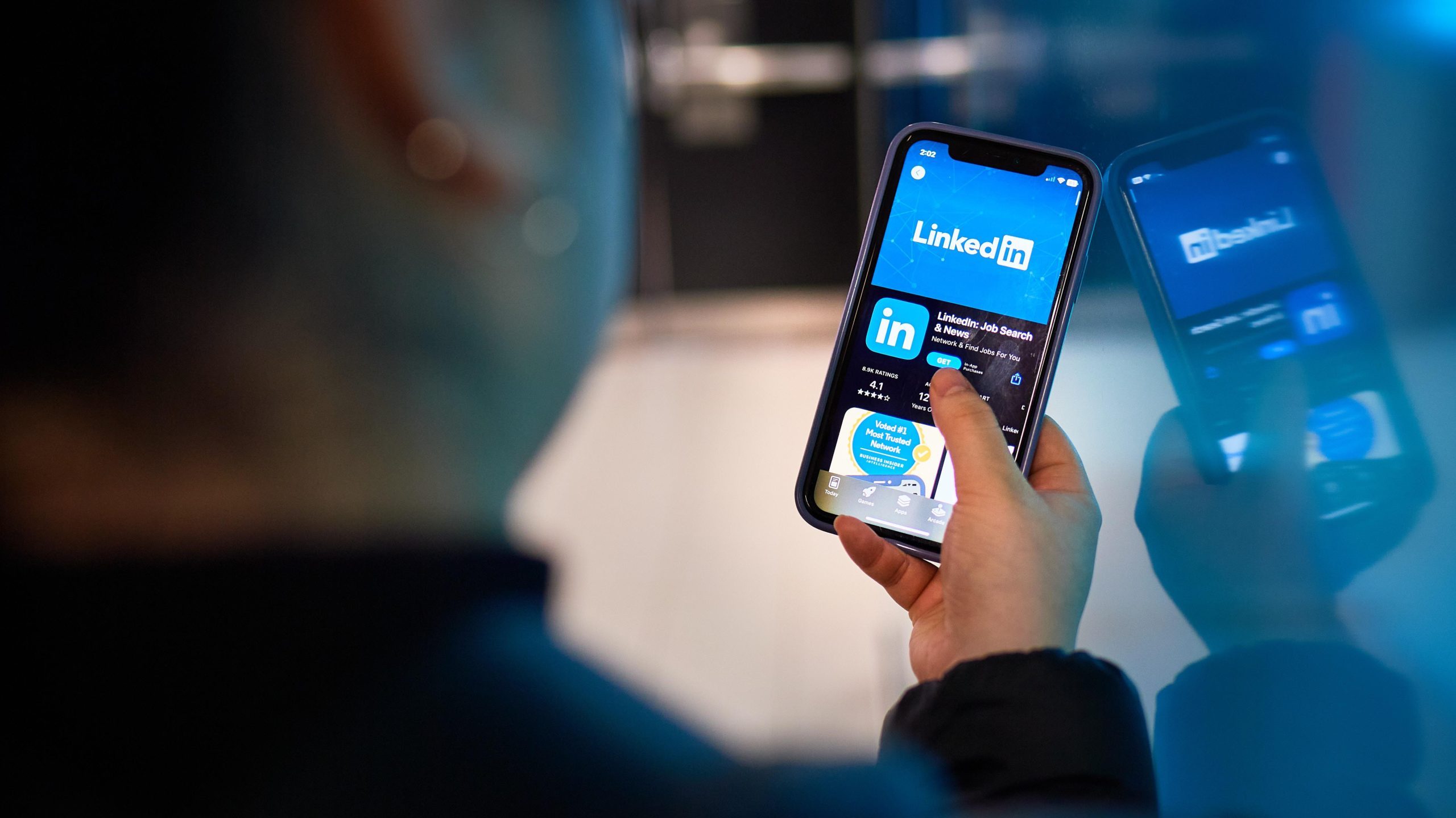 Man holds phone with Linkedin app