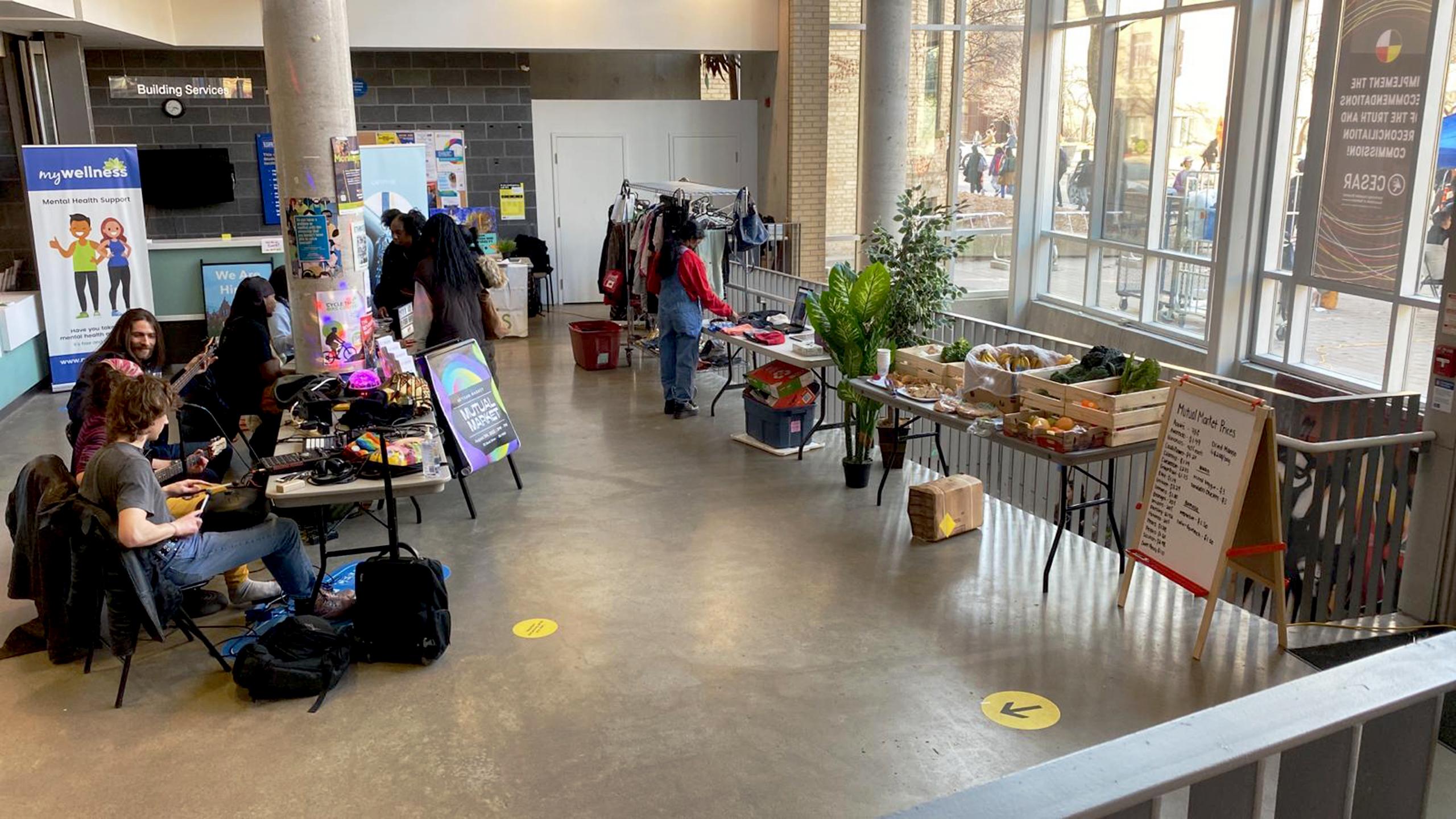 Stands with food and goods in the SCC. Students are wandering around within the market