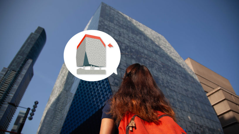 Up-facing angle of a woman facing a tall building wearing an orange backpack