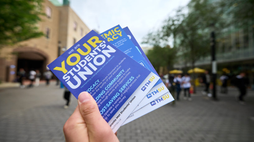 TMSU pamphlet is held up at Toronto Metropolitan University