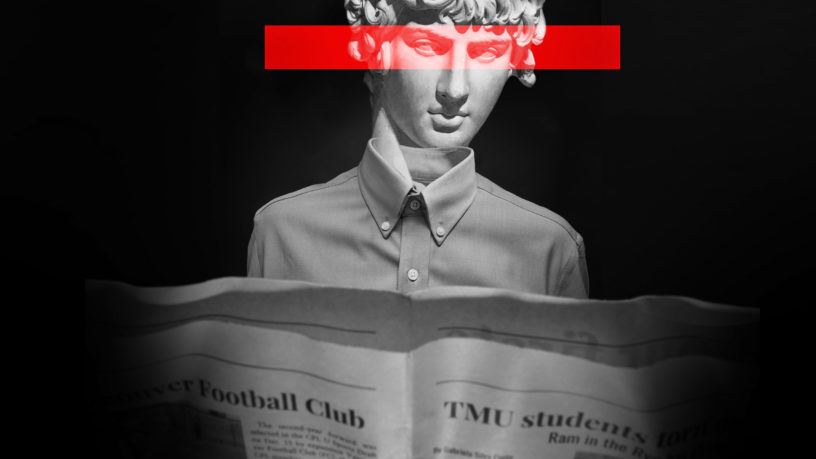 Statue with red bar across eyes wearing dress shirt reads newspaper