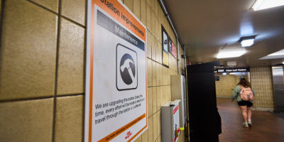 Construction sign on tiled wall of subway station