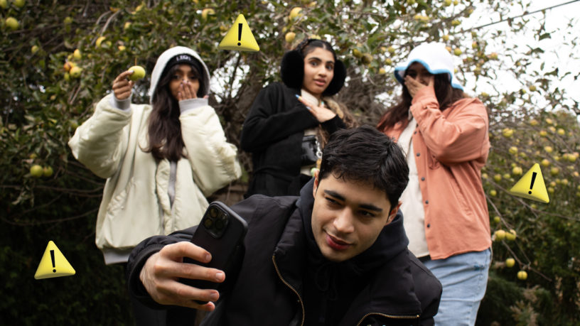 Man taking a selfie with people in the background looking surprised