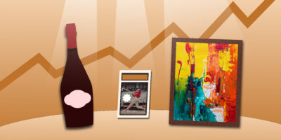Wine bottle, sports card and paining with spotlights shining on the items