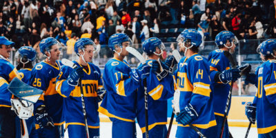 TMU Bold men's hockey team captain Chris Playfair fistbumps his teammates in celebration of a win