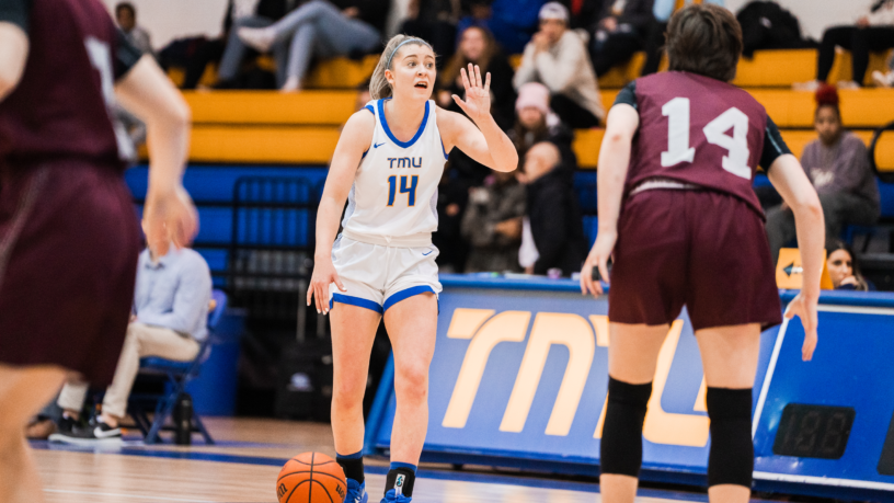 TMU Bold basketball player Kaillie Hall dribbles a basketball against an opposing player at the Mattamy Athletic Centre