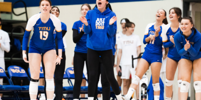 Members of the TMU Bold women's volleyball team celebrate on the bench