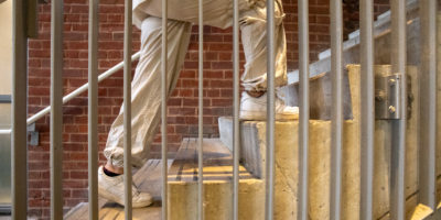 A person shot from the legs down walks up a flight of stairs