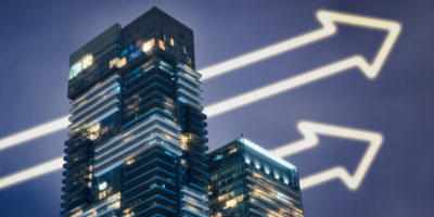 Two condo buildings with increasing arrows going through buildings