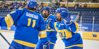 Members of the TMU Bold women's hockey team celebrate