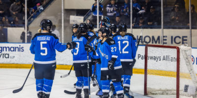 PWHL Toronto players celebrate their win with their goaltender on the ice