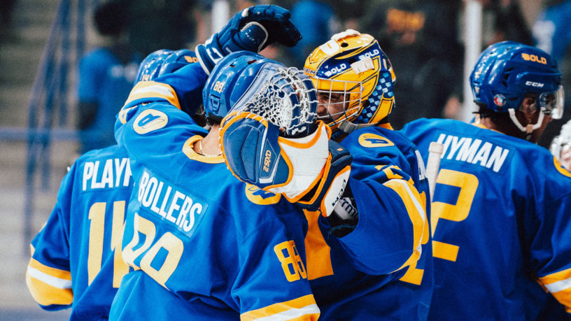 TMU men's hockey players Kyle Bollers and Kai Edmonds hug each other after a win