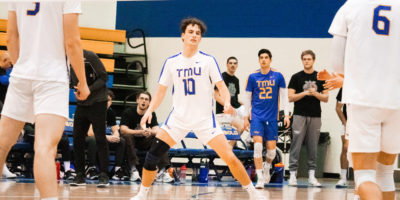 TMU men's volleyball player Taylor Wenzel stands on the court with a disappointed look