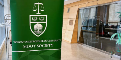 The TMU MOOT society sign in a hallways