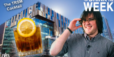 to the left, an image of a brown drink with a lemon slice in it, to the right a white man with brown hair holding his glasses and smiling