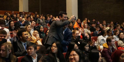 people standing in a crows of people sitting and cheering
