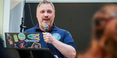 man speaking behind podium at conference