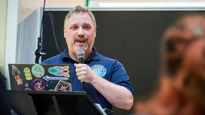 man speaking behind podium at conference