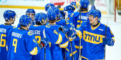 The TMU men's hockey team fist bump each other while skating on the ice in celebration of a win