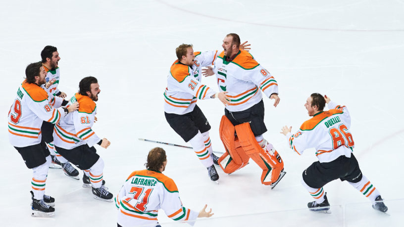 Many UQTR jump on the ice with their helmets off as they embrace each other in celebration of the win