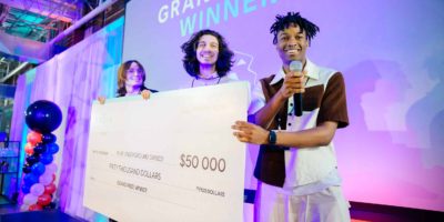 Three people hold cheque for $50,000