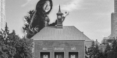 monster with the face of a woman towering over a building