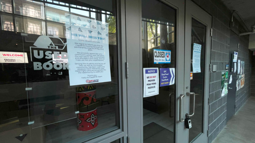 outside photo of a closed printing business with signs attached to the glass