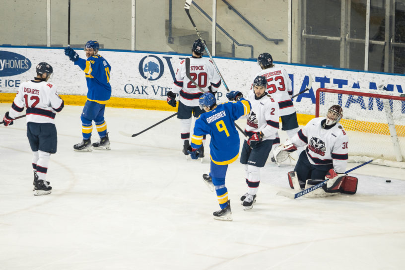 Daniil Grigorev pumps his fist to celebrate a goal in front of the Brock Badgers net