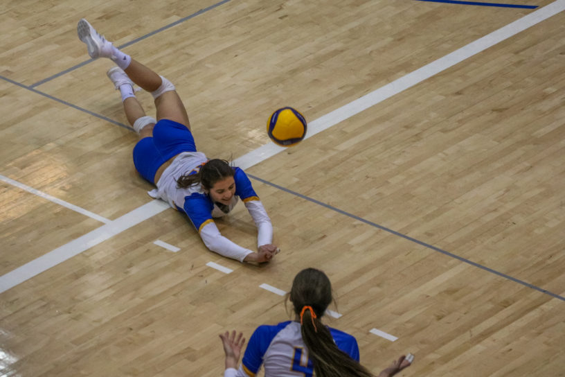 Scarlett Gingera dives for a volleyball