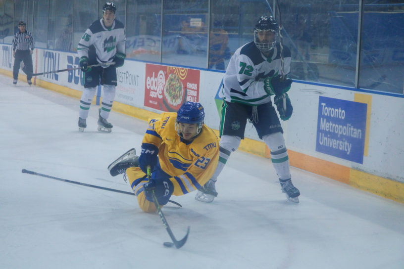 Matthew Kinash handling the puck as he's falling to the ground