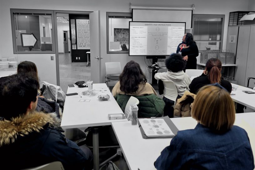A group of students watch a presentation.