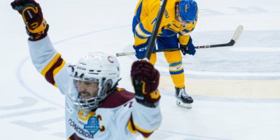 A Concordia player celebrating the win with a Bold player in the background looking down