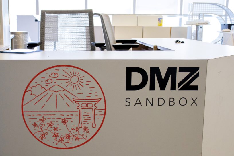 A photo illustration of the DMZ front desk stamped with an outlined image of Japan.