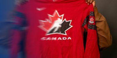 A photo of someone holding up a partially blurred Canada hockey shirt.
