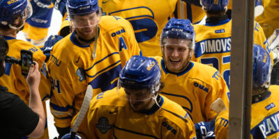 The TMU Bold gather on the ice next to the glass